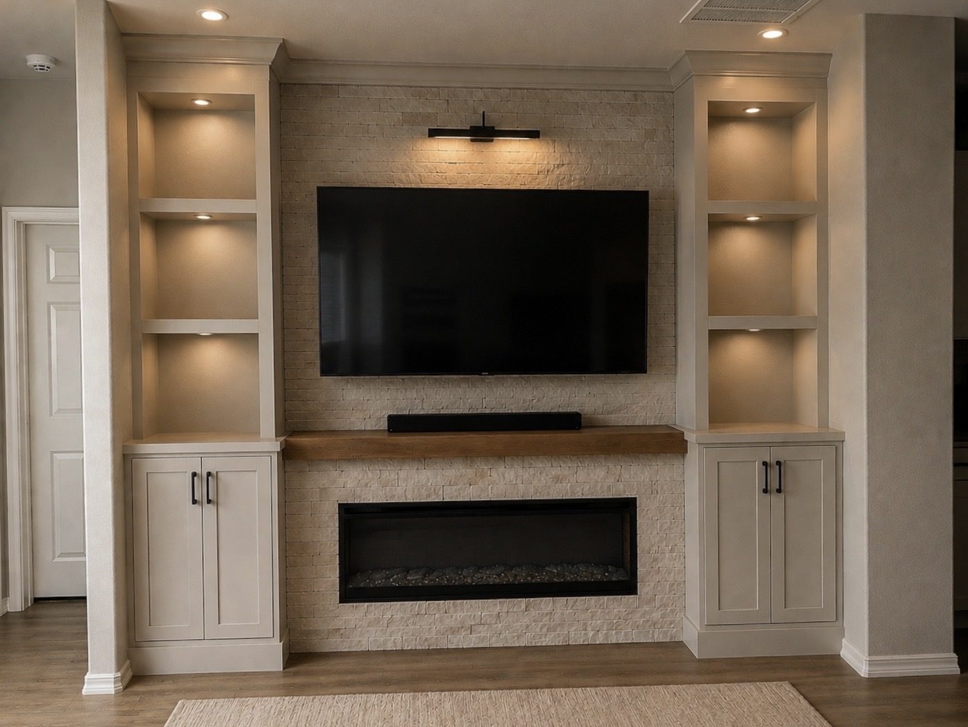 Custom great-room built-ins flanking a stacked-stone fireplace wall
